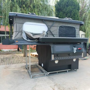 Klappbarer Wohnanhänger mit einem geneigten Dach und einer schwarzen Bodenplatte.