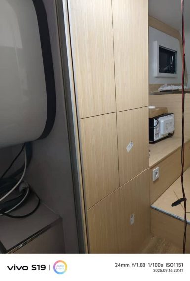 Küchenzeile mit Holzschränken, Mikrowelle und Waschmaschine.