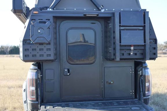 Schwarze Rückseite eines Fahrzeugs mit einer Tür und zusätzlichen Ablagen.