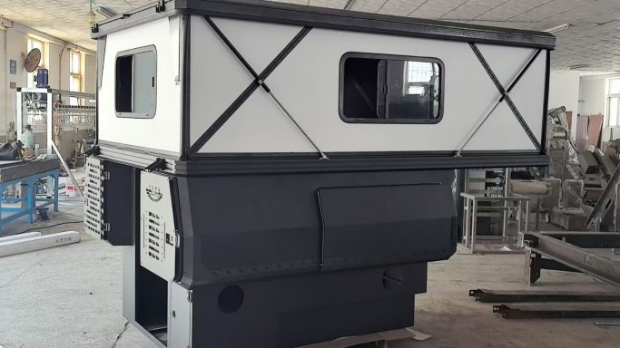 Modulare Fahrzeugbox mit zwei Fenstern, in einem Produktionsraum platziert.