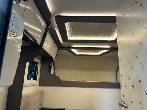 Moderne Innenansicht eines Fahrzeugs mit hellen Deckenleisten und funktionaler Ausstattung.