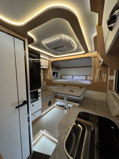 Modernes Wohnmobil-Interieur mit stilvollem Design und indirekter Beleuchtung.