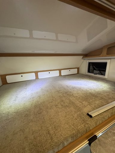 Gemütlicher Innenraum mit großem Bett und Holzverkleidung. Beleuchtet und hell.