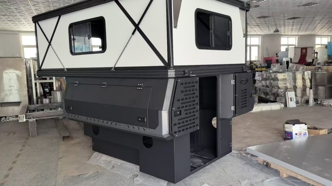 Modular Wohnkabine mit schwarzen und weißen Elementen, in einem Ausstellungsraum.