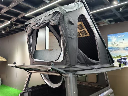 Dachzelt auf einem Fahrzeug mit Fenster und offenen Seiten, ideal für Camping.