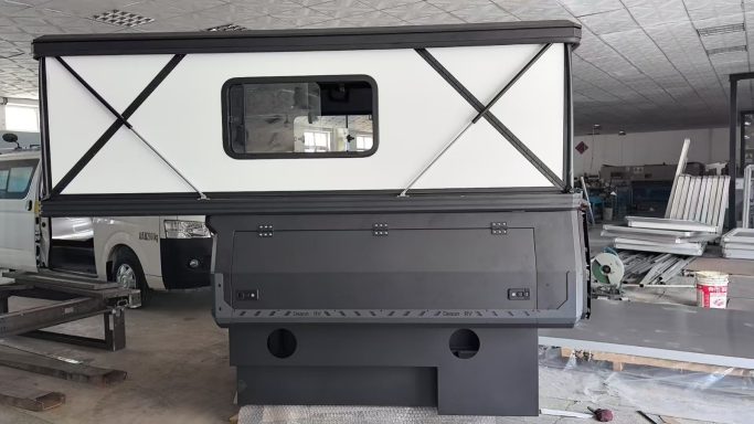 Ein schwarzer Lastwagenaufsatz mit einem weißen, quer gestreiften Fenster.