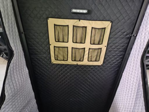 Schwarze, gepolsterte Oberfläche mit sechseckigem, ockerfarbenem Fach.