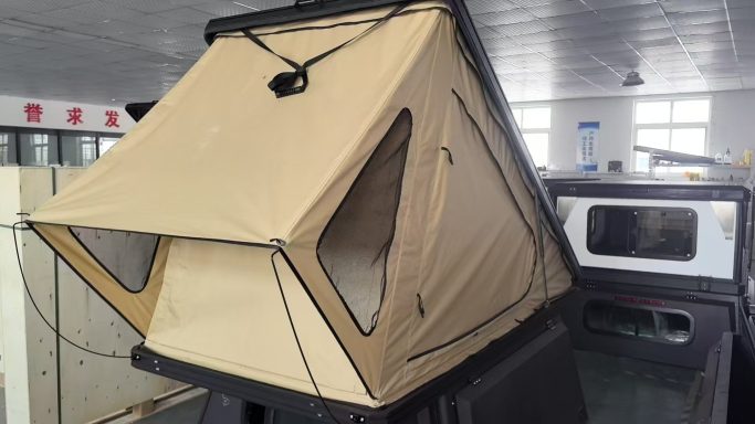 Dachzelt in beige auf einem Fahrzeug, mit seitlichen Fenstern für Belüftung.