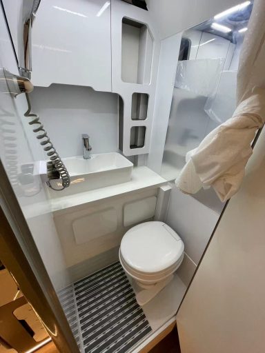 Kompakter, moderner Badezimmerbereich mit Toilette und Waschbecken.