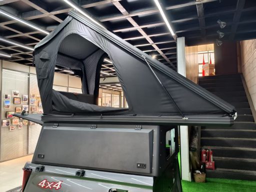 Faltbares Dachzelt auf einem Fahrzeug, schwarz, mit geöffnetem Eingang.